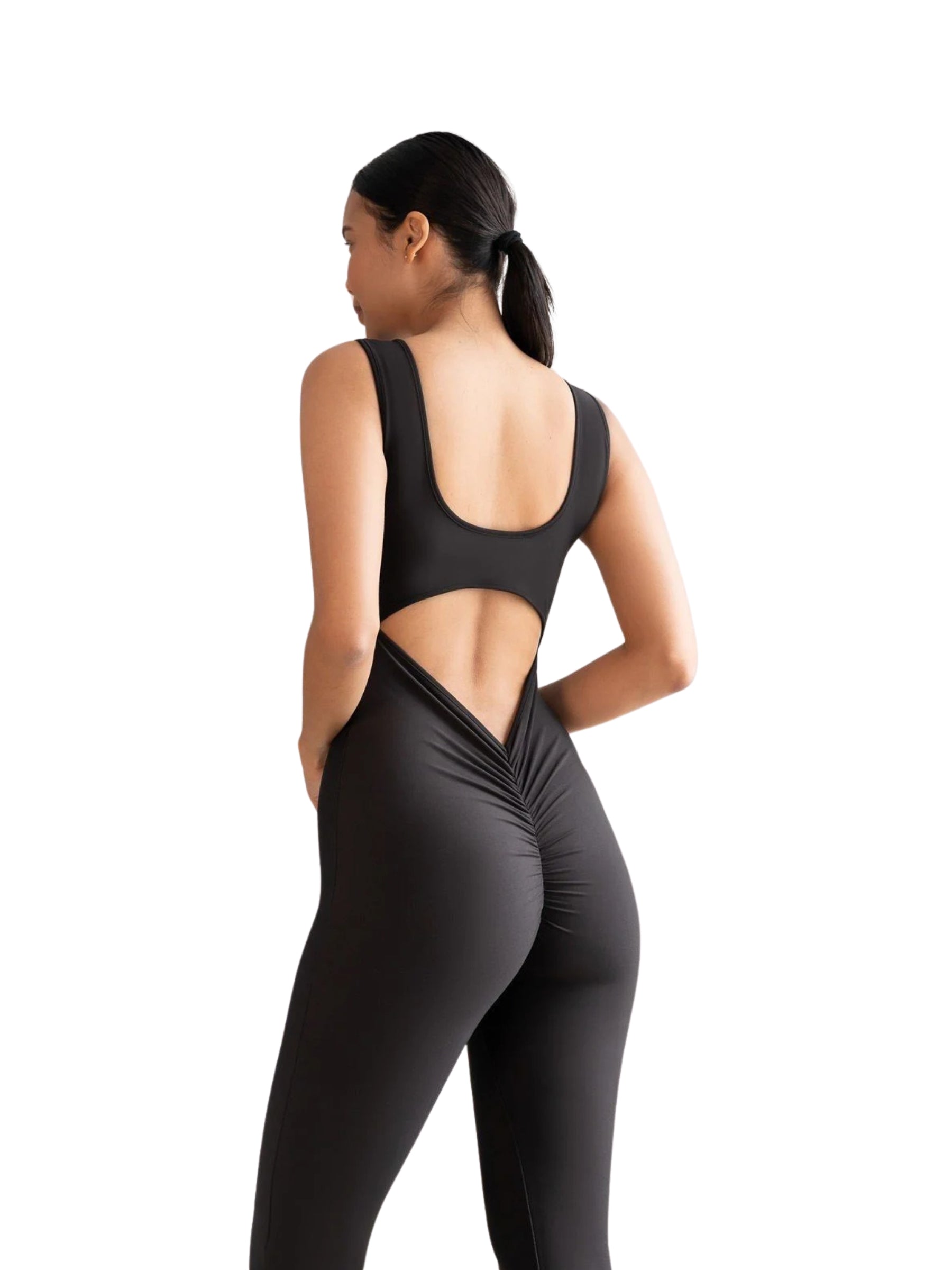 Person in einem Lismina 1500 Spanish Scrunch Butt Jumpsuit in Schwarz, vor einem weißen Hintergrund stehend.